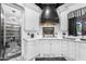 This kitchen features white cabinets, marble countertops, stainless steel appliances, a black range hood, and patterned tile floors at 3446 E Knoll St, Mesa, AZ 85213