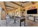Inviting covered patio boasts a foosball table, ceiling fans, and multiple seating areas for relaxing and entertaining at 3446 E Knoll St, Mesa, AZ 85213