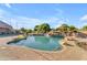 Resort-style pool area boasts a rock waterfall, lush landscaping, and a brick paver surround, ideal for relaxation at 3446 E Knoll St, Mesa, AZ 85213