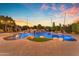 Stunning pool area featuring a rock waterfall, custom lighting, and lush landscaping, perfect for relaxation at 3446 E Knoll St, Mesa, AZ 85213