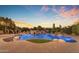 A stunning pool features a rock waterfall, lush landscaping, and a unique design, perfect for outdoor relaxation and entertainment at 3446 E Knoll St, Mesa, AZ 85213