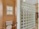 Bathroom featuring toilet next to privacy window and glass block shower at 34714 N 21St Ln, Phoenix, AZ 85086