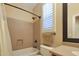 Bathroom featuring neutral tile, window with shutters, and combination tub/shower at 34714 N 21St Ln, Phoenix, AZ 85086