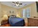 Bedroom featuring wood floors, ceiling fan, and window with shutters at 34714 N 21St Ln, Phoenix, AZ 85086