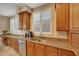 Kitchen featuring granite countertops, stainless steel appliances, wood cabinets, and ample natural light through shuttered windows at 34714 N 21St Ln, Phoenix, AZ 85086