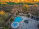An aerial view showcasing the pool, spa, and desert landscape in backyard, offering a private retreat with lounge chairs at 39877 N 107Th Way, Scottsdale, AZ 85262