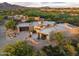 Expansive aerial view of a stunning home nestled in a picturesque desert landscape near a golf course and mountains at 39877 N 107Th Way, Scottsdale, AZ 85262
