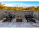 Back patio featuring an outdoor sitting area with a fire pit table and views of desert landscaping at 39877 N 107Th Way, Scottsdale, AZ 85262