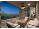 Back patio featuring an outdoor sitting area, a stone wall, shade, and desert landscaping at 39877 N 107Th Way, Scottsdale, AZ 85262
