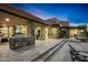 Expansive backyard with a covered patio, built-in stone kitchen, lounge chairs, and desert views, ideal for relaxation at 39877 N 107Th Way, Scottsdale, AZ 85262