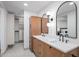 Modern bathroom featuring double vanity, wood cabinetry, arched mirrors, and a walk-in closet at 39877 N 107Th Way, Scottsdale, AZ 85262