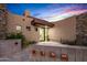 Inviting home entrance with desert landscaping, a stone accent wall, and a modern glass front door at 39877 N 107Th Way, Scottsdale, AZ 85262