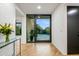 Bright foyer featuring hardwood floors, a glass console table with flowers, and a view of the backyard at 39877 N 107Th Way, Scottsdale, AZ 85262