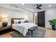 Bright main bedroom featuring a sliding barn door, ceiling fan, and stylish decor on hardwood floors at 39877 N 107Th Way, Scottsdale, AZ 85262