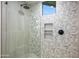 Modern shower featuring stylish geometric patterned tile, a niche, a glass enclosure, and rainfall shower head at 39877 N 107Th Way, Scottsdale, AZ 85262