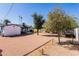 Wide shot of the backyard with gravel landscaping, some cacti, trees and a patio at 406 W Coolidge St, Phoenix, AZ 85013