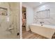 Luxurious bathroom boasting a soaking tub, a walk-in shower, marble walls, and a large walk-in closet at 406 W Coolidge St, Phoenix, AZ 85013