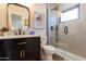 Modern bathroom with a sleek vanity, black fixtures, a decorative mirror and a glass-enclosed shower at 406 W Coolidge St, Phoenix, AZ 85013