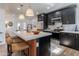 Modern kitchen with stainless steel appliances, marble countertops, black cabinets, and seating at the central island at 406 W Coolidge St, Phoenix, AZ 85013