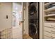 Convenient laundry room with stacked washer and dryer, built-in shelving, and easy access to the rest of the home at 406 W Coolidge St, Phoenix, AZ 85013