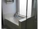 Bathroom featuring a bathtub with glass shower doors and tile surround at 4150 E Harvard Ave, Gilbert, AZ 85234