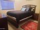 Bedroom with a wooden bed frame and a red accent rug at 4150 E Harvard Ave, Gilbert, AZ 85234