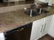 Close-up of the kitchen sink with granite countertops and white cabinetry at 4150 E Harvard Ave, Gilbert, AZ 85234