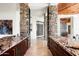 Elegant bar area featuring stone pillars, marble countertops and a climate-controlled wine rack at 42690 N 98Th Pl, Scottsdale, AZ 85262