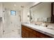 Modern bathroom with a spacious walk-in shower, tiled floors, and a vanity with a large mirror at 42690 N 98Th Pl, Scottsdale, AZ 85262
