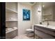Well-lit bathroom featuring floating vanity, modern fixtures, open shelving, and contemporary art at 42690 N 98Th Pl, Scottsdale, AZ 85262