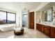 Bright primary bathroom features a soaking tub, walk-in shower, dual vanities, and mountain views at 42690 N 98Th Pl, Scottsdale, AZ 85262
