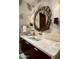 Stylish bathroom with a unique mirror, sconces, stone countertop, and elegant fixtures at 42690 N 98Th Pl, Scottsdale, AZ 85262