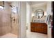 Contemporary bathroom with a glass-enclosed shower, dual sinks, and a warm neutral color palette at 42690 N 98Th Pl, Scottsdale, AZ 85262