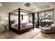 Elegant bedroom featuring a four-poster bed, soft lighting, and an outdoor patio with comfortable seating at 42690 N 98Th Pl, Scottsdale, AZ 85262