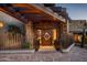Modern entrance with a unique wood-beam pergola and a custom wood door with diamond embellishment at 42690 N 98Th Pl, Scottsdale, AZ 85262