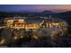 Stunning modern home featuring stone accents, landscape lighting and mountain views at twilight at 42690 N 98Th Pl, Scottsdale, AZ 85262