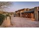 Expansive brick driveway and large, multi-car garage featuring elegant wooden doors and stone detailing at 42690 N 98Th Pl, Scottsdale, AZ 85262