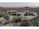 Sprawling modern home boasts stone facade, mature landscaping, a circular driveway, and desert views at 42690 N 98Th Pl, Scottsdale, AZ 85262