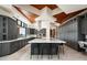 Spacious kitchen with a large marble island, gray cabinets, wood ceiling, and stainless appliances at 42690 N 98Th Pl, Scottsdale, AZ 85262
