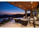 Serene outdoor patio at twilight with mountain views, an infinity pool and comfortable seating at 42690 N 98Th Pl, Scottsdale, AZ 85262