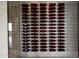 Close-up of the climate-controlled wine rack featuring individual bottle holders and glass enclosure at 42690 N 98Th Pl, Scottsdale, AZ 85262