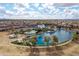 Aerial view of community pool with ample seating and a lake surrounded by lush landscaping at 4769 E Thunderheart Trl # 101, Gilbert, AZ 85297