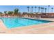 Inviting community swimming pool with lounge chairs, umbrellas, and crystal-clear water at 5221 E Mills Ct, Mesa, AZ 85215