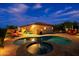 Night view of a backyard featuring a pool, spa, and beautifully lit landscaping at 6044 E Hodges St, Cave Creek, AZ 85331