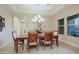 Dining room with wood table, chairs, chandelier, and view through two windows at 6044 E Hodges St, Cave Creek, AZ 85331