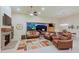 Inviting living room featuring a stone fireplace, leather seating, and mountain views through sliding glass doors at 6044 E Hodges St, Cave Creek, AZ 85331