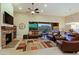 Comfortable living room featuring a fireplace, ceiling fan, and sliding glass doors leading to the backyard at 6044 E Hodges St, Cave Creek, AZ 85331