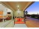 Covered patio with orange cushioned seating and a view of the desert landscape at sunset at 6044 E Hodges St, Cave Creek, AZ 85331