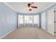 Light-filled primary bedroom boasts blue walls, plush carpet, and a ceiling fan at 617 N Cobblestone St, Gilbert, AZ 85234