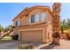 Two-story home featuring a tile roof, two car garage, and desert landscaping with mature palm trees at 617 N Cobblestone St, Gilbert, AZ 85234